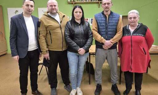 pięć osób pozuje do zdjęcia
