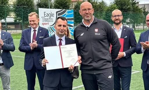 na zdjęciu z przodu od lewej Burmistrz Dobrzan trzymający podpisany dokument, obok Minister Sportu i Turystyki.